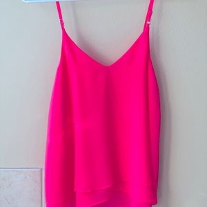 Bright pink flowy tank top. Double layer polyester. Hits at hips